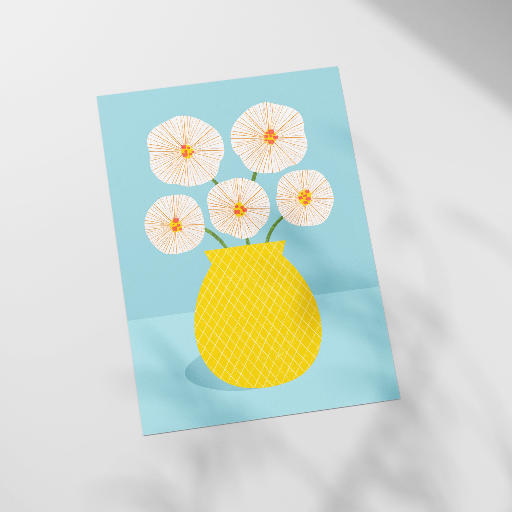 a yellow vase filled with white flowers on top of a table