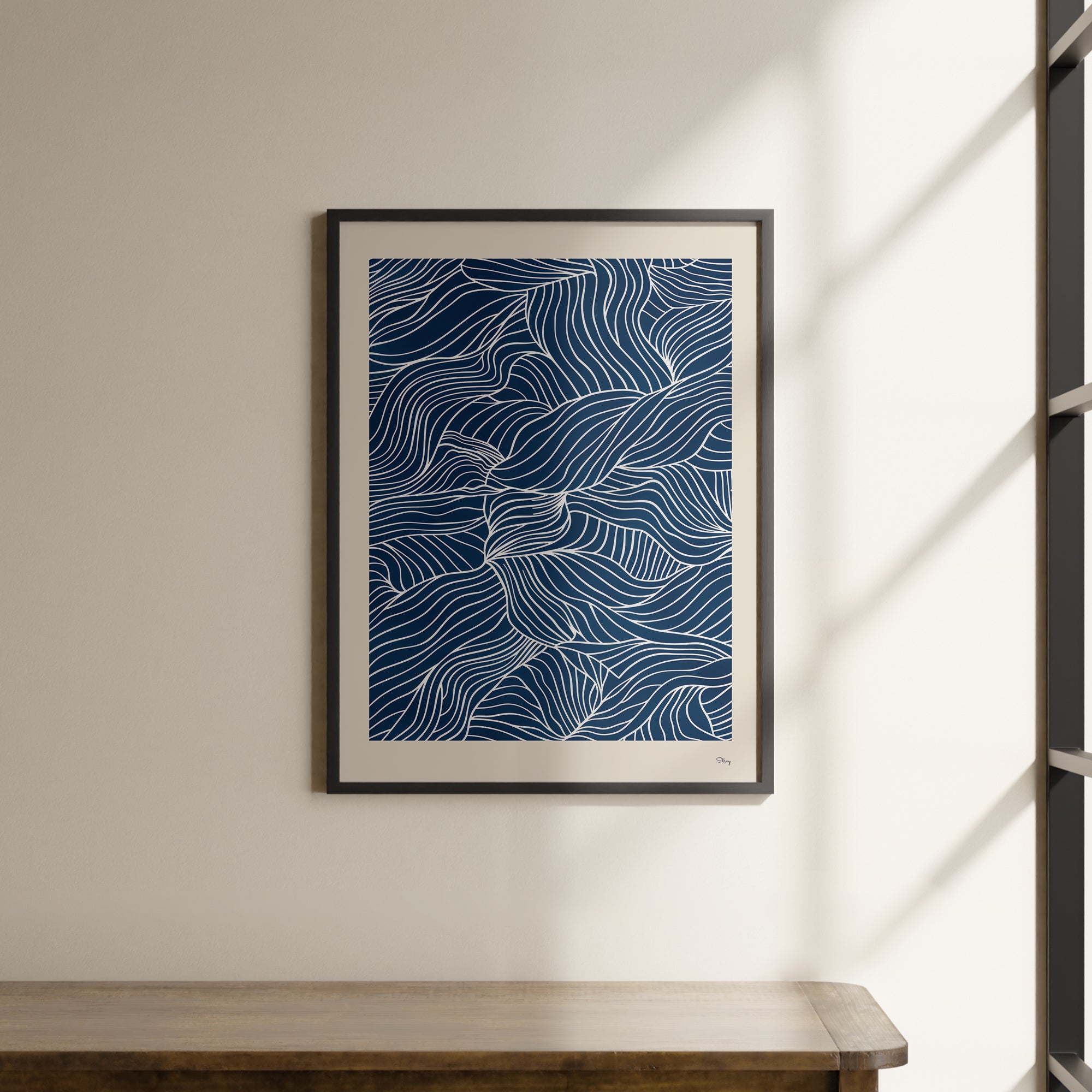 a picture hanging on a wall above a wooden table