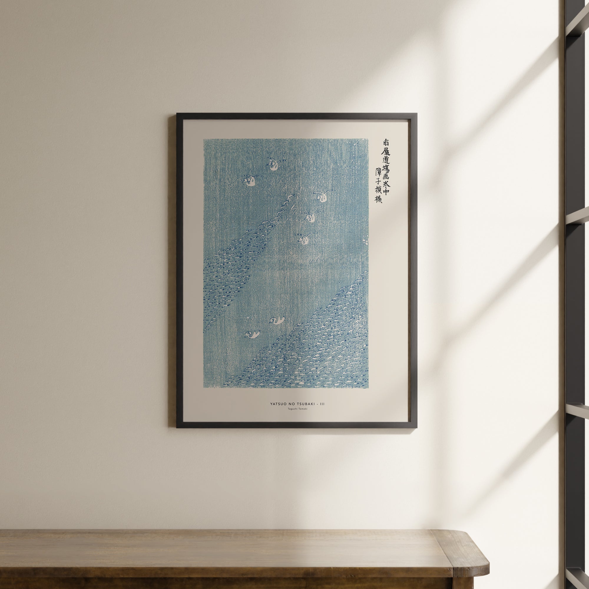 a picture hanging on a wall above a wooden table