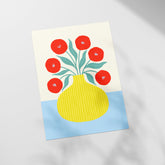 a picture of a yellow vase with red flowers