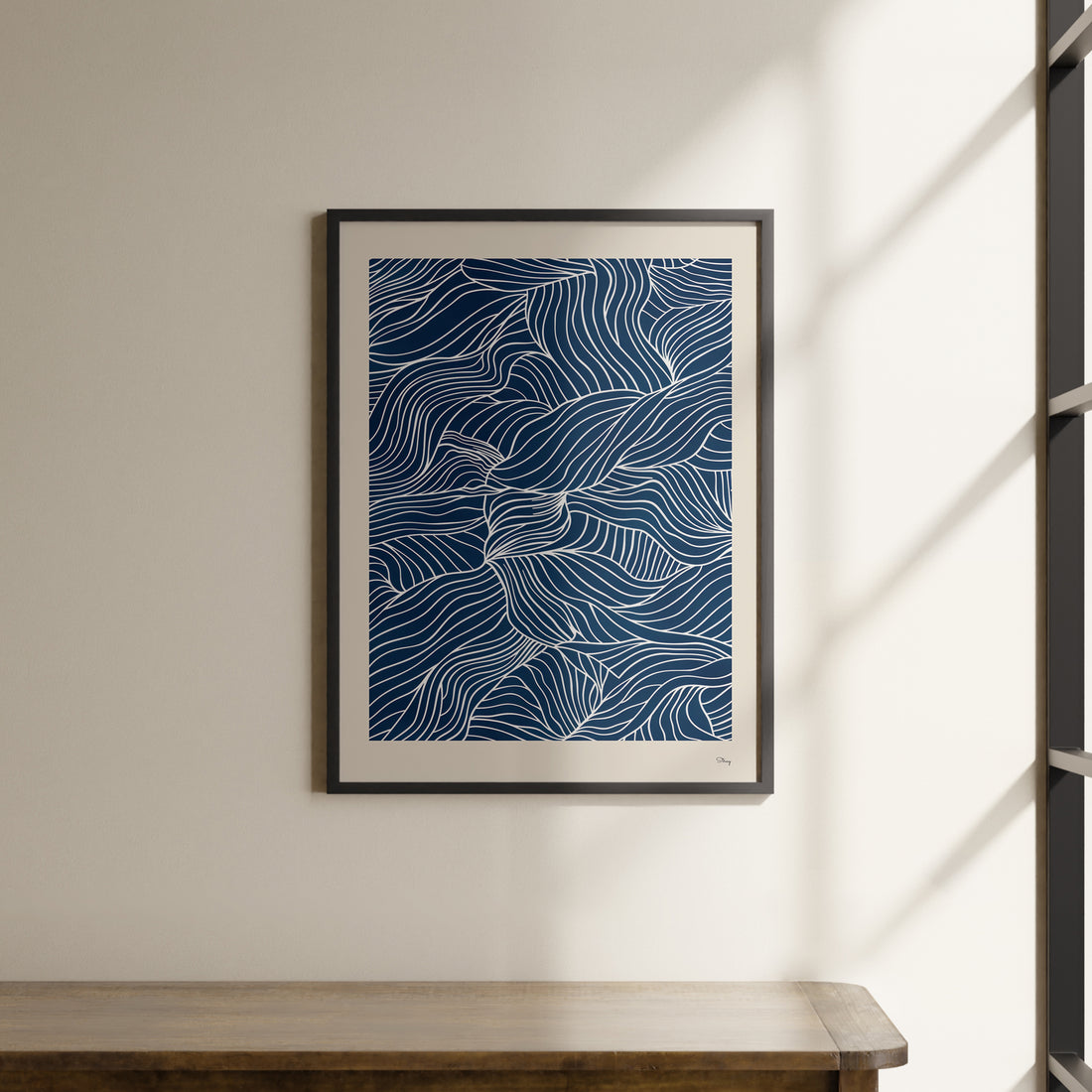 a picture hanging on a wall above a wooden table