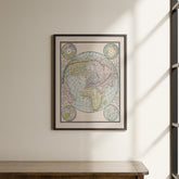 a framed map of the world hanging on a wall